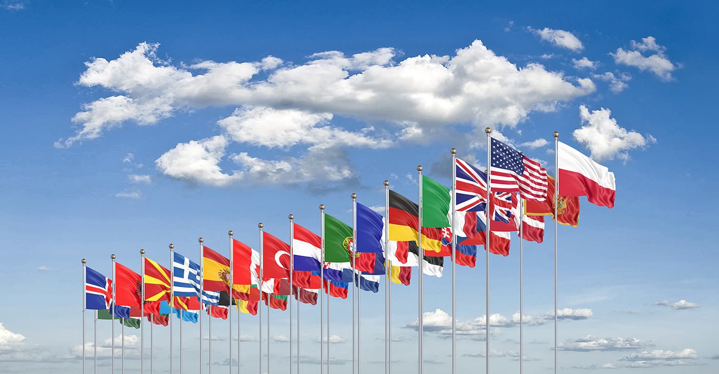 NATO flags waving against a blue sky
