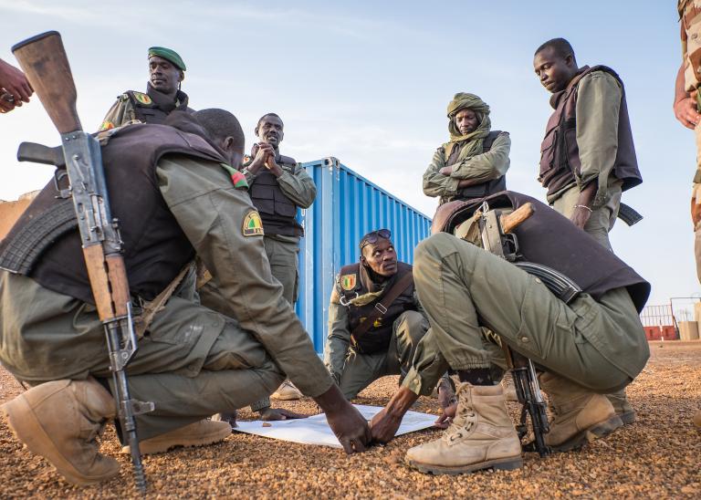 Des soldats s'agenouillent autour d'une carte de planification stratégique pendant l'opération militaire Barkhane au Mali. 